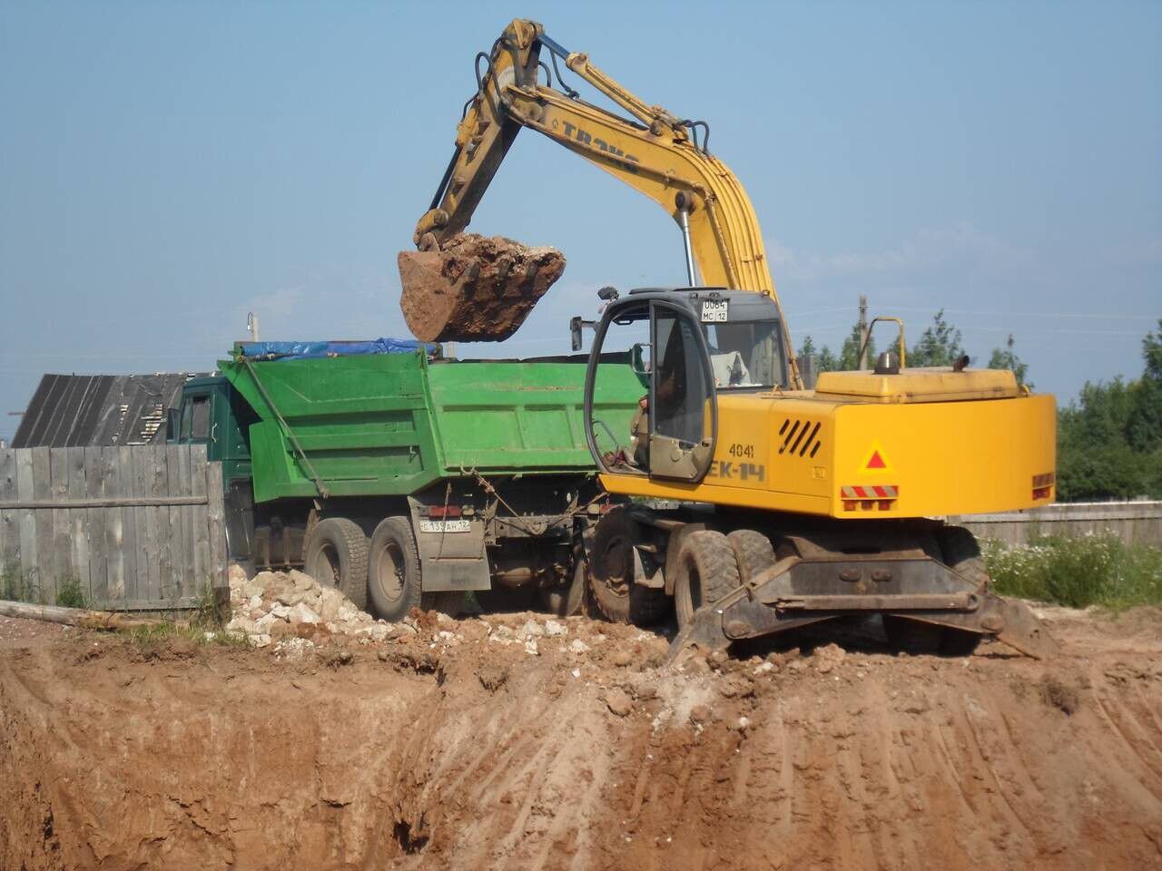 Экскаватор твэкс буксирует камаз. Экскаватор грузит. Погрузка грунта экскаватор jcb. Экскаватор грузит. Услуги экскаватора погрузчика и самосвала.