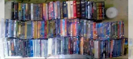 коллекция DVD дисков с сериалами на полке у телевизора