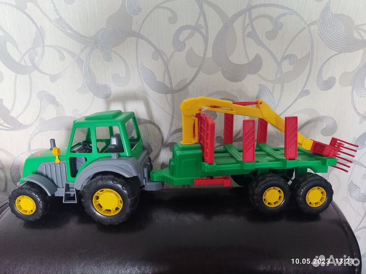 Трактор с прицепом, бревнами и цепляющим краном