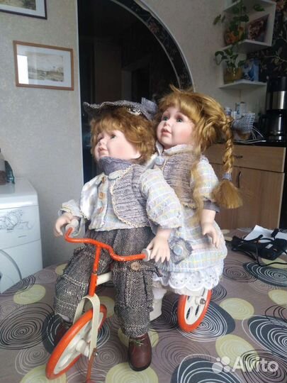 Пара фарфоровых кукол на велосипеде